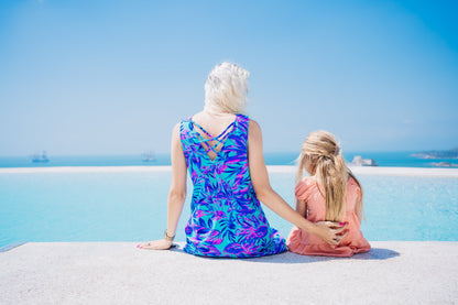 Woman in a Summer Beach Swim Dress sitting by the pool with kids, showcasing the dress's comfort and versatility for beach or evening wear.